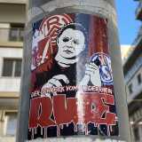 Di fronte all�Ateneo troviamo un adesivo in salsa splatter. Da uno sfondo rosso sangue emerge la minacciosa figura di Michael Myers, il killer soprannaturale della saga horror �Halloween�. L�assassino rappresenta metaforicamente lo Schalke 04, squadra di serie A tedesca, che con il suo coltello minaccia di portarsi a casa lo scalpo delle rivali Eintracht Francoforte ed Essen